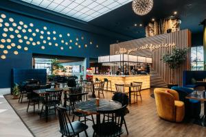 a restaurant with tables and chairs and a bar at Naumi Auckland Airport Hotel in Auckland