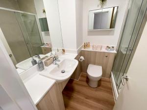 a bathroom with a sink and a toilet and a shower at Riverside House at Guildford in Guildford