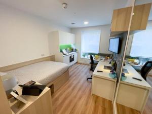 a bedroom with a bed and a desk with a computer at Riverside House at Guildford in Guildford
