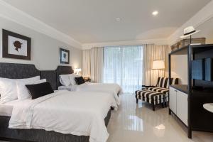 a hotel room with two beds and a flat screen tv at Sugar Marina Hotel - FASHION - Kata Beach in Kata Beach