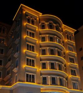 a tall building with yellow lights on it at ايليفار بلس Elevar plus Hotel in Al Khobar