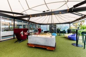 a tent with chairs and a table and an umbrella at Naumi Auckland Airport Hotel in Auckland