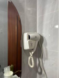 a white phone hanging on a wall in a bathroom at Pensión Capital de Galicia in Santiago de Compostela +33 photos