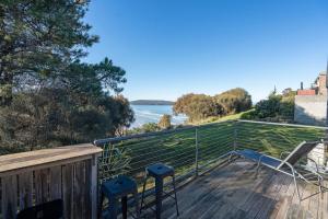 a balcony with two chairs and a view of the water at Seascape Cottage - Headland Stay near Whale Watching in Dodges Ferry