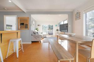 a living room with a table and a dining room at Seascape Cottage - Headland Stay near Whale Watching in Dodges Ferry
