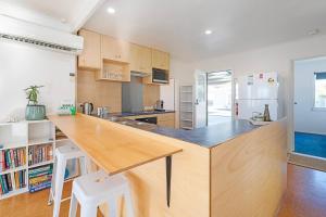 a kitchen with a large wooden island in a room at Seascape Cottage - Headland Stay near Whale Watching in Dodges Ferry