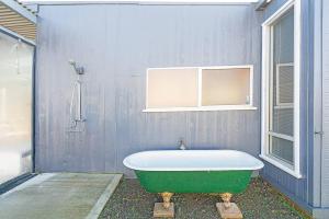 a green bath tub in a bathroom with a wall at Seascape Cottage - Headland Stay near Whale Watching in Dodges Ferry +26 photos