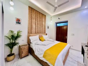a bedroom with a large bed with a yellow blanket at Dyson Ville in Dehradun