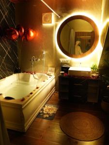a bathroom with a tub and a sink and a mirror at Dyson Ville in Dehradun