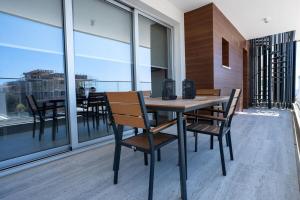 a wooden table and chairs on a balcony at Modern Apartment, Walking Distance to Beach, Hot Tub, BBQ in Paphos City