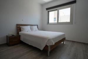 a bedroom with a large bed and a window at Modern Apartment, Walking Distance to Beach, Hot Tub, BBQ in Paphos City