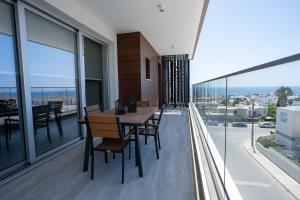 a dining room with a table and chairs on a balcony at Modern Apartment, Walking Distance to Beach, Hot Tub, BBQ in Paphos City