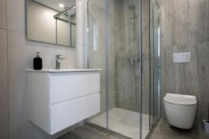 a bathroom with a shower and a toilet and a sink at Modern Apartment, Walking Distance to Beach, Hot Tub, BBQ in Paphos City +28 photos
