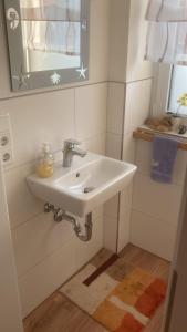 a bathroom with a white sink and a mirror at Ferienwohnung Christel in Erlenbach am Main