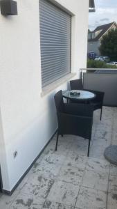 a patio with a table and chairs and a window at Ferienwohnung Christel in Erlenbach am Main