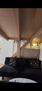 a black couch in a room with a ceiling at Sweet Escape -T1 bis romantique in Bourg-lès-Valence