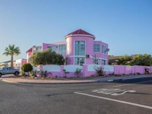 a pink building on the side of a street at Somerset Nest Lodge in Somerset West