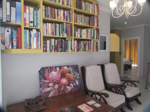 a room with two chairs and a table with books at Somerset Nest Lodge in Somerset West