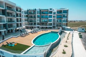 un immeuble d'appartements avec une piscine devant dans l'établissement Carisa Elysium Larnaca, à Larnaka