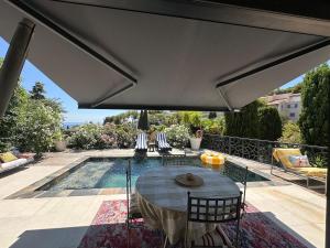 um pátio com mesa e cadeiras e uma piscina em T3 luxe vue mer em Cassis