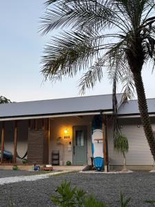 a house with a palm tree in front of it at ゲストハウス sou 海と森のテラス 2025年夏オープン in Tatsugo