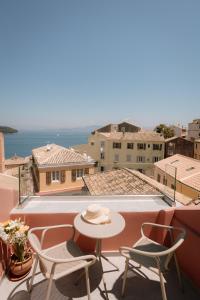 CorfuIonea House的阳台上配有桌椅的露台