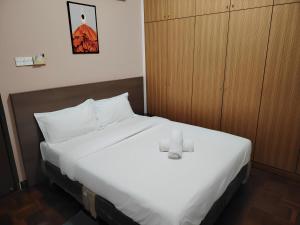 a bedroom with a large white bed and wooden cabinets at Natol Homestay - Sydney Batu Kawa MJC New Townships in Kampong Sandong