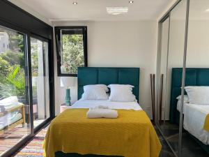 um quarto com uma cama grande com um cobertor amarelo em T3 luxe vue mer em Cassis