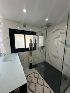 uma casa de banho com uma estátua de um homem num chuveiro em T3 luxe vue mer em Cassis