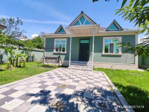 a green house with a checkered driveway in front of it at QQS villa with swimming pool in Gabala