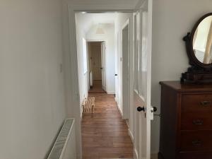 einen Flur mit einem Spiegel und Holzboden in der Unterkunft Berryhill Maids Quarters - 3 bedroom - Self Catering - Sleeps 3 - Dogs Welcome - Off-road Parking - Suit Contractors - Peterhead 1 mile - Newly Refurbished - Open plan kitchen -living - dining - 2 bathroom - Shed - Yard -Drying Room available in Peterhead