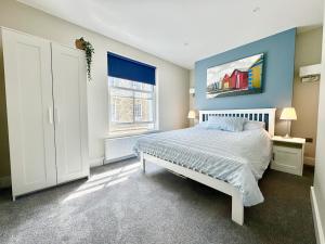 een slaapkamer met een bed en een groot raam bij Castle Cottage - Central seaside town in Ryde