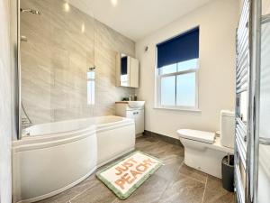 een badkamer met een bad, een toilet en een wastafel bij Castle Cottage - Central seaside town in Ryde +9 foto's
