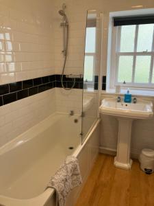 ein Badezimmer mit Badewanne und Waschbecken in der Unterkunft Berryhill Maids Quarters - 3 bedroom - Self Catering - Sleeps 3 - Dogs Welcome - Off-road Parking - Suit Contractors - Peterhead 1 mile - Newly Refurbished - Open plan kitchen -living - dining - 2 bathroom - Shed - Yard -Drying Room available in Peterhead