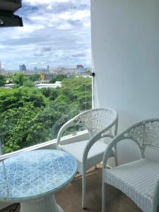 two chairs and a table on a balcony with a view at Hotel Kann Pattaya in Pattaya South +33 photos