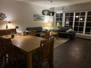 ein Wohnzimmer mit Tisch und Couch in der Unterkunft Ferienhaus Berg in Sylt