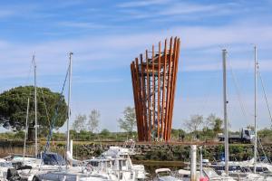 a large wooden chair in a marina with boats at T2 élégant plus piscine in Le Teich