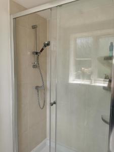 eine Dusche mit Glastür im Badezimmer in der Unterkunft The Grange Cute Modern Stay in Gerrards Cross + 4 Fotos