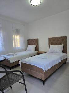 a bedroom with two beds and a chair in it at Apartments Duga Ulcinj in Ulcinj