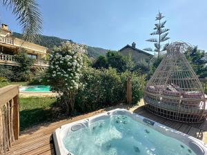 wanna z hydromasażem na tarasie z klatką dla ptaków w obiekcie Petit coin de paradis, vue panoramique mer &montagne, piscine privée... w mieście Calcatoggio