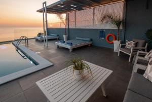 una sala de estar con una piscina y una mesa y una mesa en Blue Green Villa Kalyves eco pool premium quality, en Kalyves