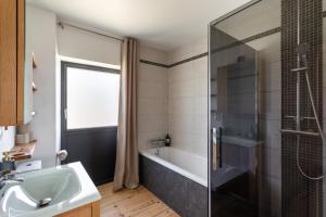 a bathroom with a tub and a sink and a shower at La Si Lancieuse - Maison spacieuse in Lancieux