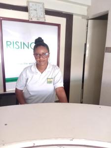 a woman standing in front of a screen at Rising Sun Hotel in Mwanza