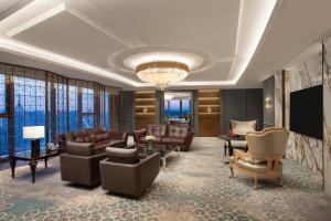 a living room with leather furniture and a flat screen tv at HUALUXE Handan by IHG in Handan