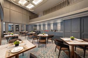 a restaurant with tables and chairs in a room at HUALUXE Handan by IHG in Handan
