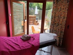 ein Schlafzimmer mit einem Bett und einer Tür zu einer Terrasse in der Unterkunft Mattie's Loft in Bletchingley