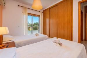 una camera d'albergo con due letti e una finestra di Apartamentos Santa Teresinha ad Alvor Altre 28 foto