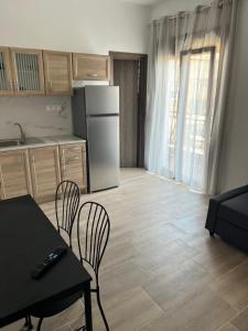 a kitchen with a table and chairs and a refrigerator at Nicks apartments in Ierissos