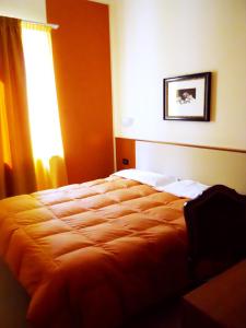 a bedroom with an orange bed with a window at Eco Art Hotel Statuto in Turin