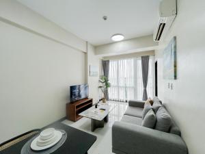 a living room with a couch and a tv at Stylish 1BR in OPR in Lapu Lapu City